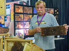 Beekeeper Jim Rogers poses for a photo at the Beekeepers’ booth at the Nutrien building on Stampede grounds on Thursday, July 14, 2022.