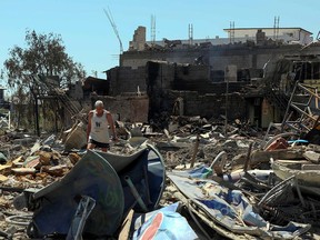 FILE PHOTO: A local resident walks among remains of residential buildings destroyed by a Russian missile strike, as Russia's attack on Ukraine continues, in the settlement of Zatoka, Odesa region, Ukraine July 26, 2022.