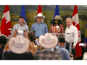 Conservative leadership candidates, from left, Roman Baber, Pierre Poilievre, Leslyn Lewis and Jean Charest stand together after each giving a short speech during the Conservative Party of Canada Stampede BBQ event held at Heritage Park in Calgary on Saturday, July 9, 2022.