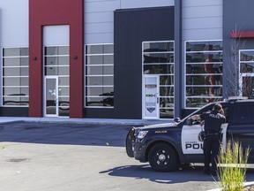 CPS officers cleaning up a scene where a man and a woman were shot and seriously injured in Calgary on Saturday, July 16, 2022.