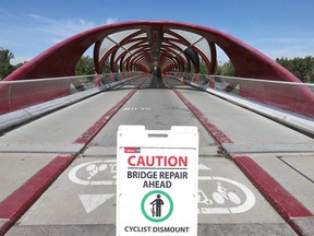 Signs notify cyclists and pedestrians of damage at the Peace Bridge.