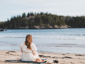 woman sitting on beach in New Brunswick