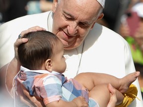 Pope Francis blesses a baby as he arrives to preside a mass at Commonwealth Stadium in Edmonton, Alberta, Canada July 26, 2022. REUTERS/Amber Bracken