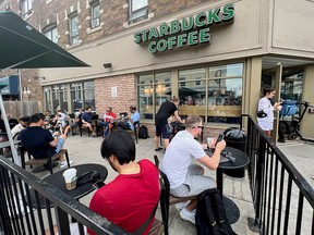 People crowd around a Starbucks coffee shop in Toronto to use its free wifi on the Bell network during a major Rogers outage on Friday.