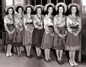 Eatons elevator operators in 1942. Stampede attire for that time included fringed skirts, shiny satin blouses and Panama-style straw hats. Cowboy boots have since replaced the pumps and casual shoes seen here.