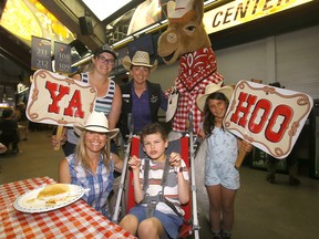 (L-R) Mom, Kristy Cutinha and aid Kerri Witherspoon with Candice Lee, event organizer Stampede Queens’ Alumni Committee, Harry the Horse and kids Haley and Ryder ham it up during the Giddy Up Grits breakfast for special needs kids and families, hosted by the Stampede Queens’ Alumni Committee in the Saddledome concourse on Monday, July 11, 2022.