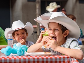 Luke, 6, takes a big bite out of his Stampede breakfast at First Flip on Stephen Avenue on Thursday.
