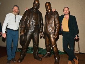 Bryan Cranston and Aaron Paul pose with bronze statues depicting television characters Walter White, played by Cranston, and Jesse Pinkman, played by Paul, from the series "Breaking Bad" at the Albuquerque Convention Center on July 29, 2022 in Albuquerque.
