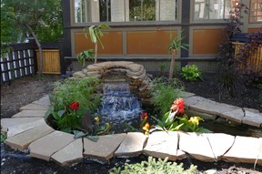 The waterfall at 11th Street Gardens spills into ponds that span the width of the entire front yard. The ponds are not drained in the fall. Rather, when the water freezes in winter, it acts as reinforcement and keeps the rockery in place. Photo, Bill Brooks