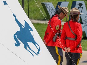 RCMP officers welcome visitors at a teepee in the Elbow River Camp at the 2022 Calgary Stampede, Saturday, July 9, 2022.