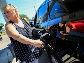 Martha Prescott-Mulligan gases up for 165.9 cents a litre at the CanPro gas station in northeast Calgary on Wednesday.