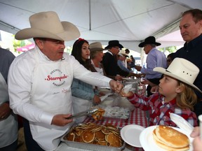 Alberta Premier Jason Kenny serves up pancakes at the Premier's Pancake Breakfast in Calgary on Monday, July 11, 2022.