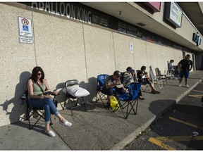 People prepare for a long night as they line up at Mississauga's Central Parkway Mall to have their passports processed the next day amid massive delays, Thursday July 7, 2022.
