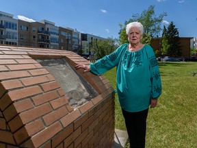 Hayla Wilson stands beside a destroyed memorial at Ukrainian Pioneers Park in Calgary.