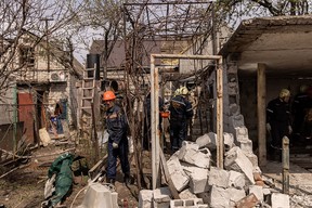 Residents and emergency services personnel work to clean up debris after a Russian attack on April 29 in Zaporizhia in southeast Ukraine.