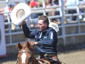 Rocky Mountain House cowboy Ben Andersen takes a victory lap around the infield after winning the day-money in the saddle- bronc event during the Calgary Stampede rodeo on Tuesday.