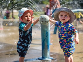 With a heat warning continuing for Calgary, cousins Fletcher, left, and Bennett, both one, cool down at the spray park at West Confederation Park on a hot summer day on Friday, July 29, 2022.