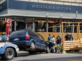 A minivan pulls out of a patio outside Bottlescrew Bill's Pub on Calgary's Beltline on Thursday.