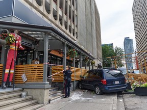 First responders are at the scene after a minivan hit by a car that was running a red light was pushed into the patio at Bottlescrew Bill's Pub in Beltline on Thursday, August 4, 2022. The incident caused no major injuries.