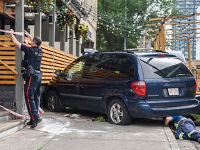 First responders are on the scene after a minivan hit by a car that ran a red light was pushed onto the patio at Bottlescrew Bill's Pub in the Beltline on Thursday, Aug. 4, 2022. The incident caused no major injuries.