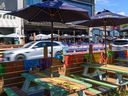 Traffic zips by patios on 17th Avenue S.W. on Friday, Aug. 5, 2022.