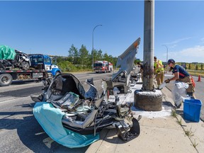 Calgary firefighters clean up the scene of a fatal car crash at the intersection of 17 Ave. and 85 St. S.W. on Saturday, August 13, 2022.