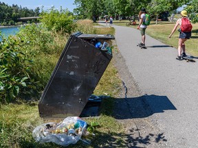 Pictured is a full garbage bin with pieces of garbage around it along Bow River pathway near Edworthy Park on Sunday, August 14, 2022.