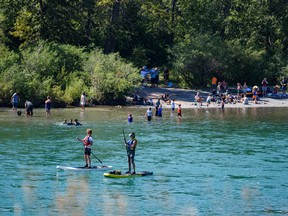 People spend a hot and sunny afternoon on and along the Bow River near Edworthy Park on Sunday, August 14, 2022.