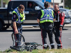 Calgary police were pictured at the scene where a cyclist was struck by a truck on Wednesday, August 17, 2022.