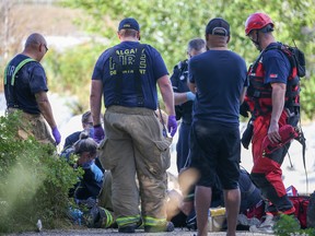 Paramedics and Calgary firefighters perform CPR on a person who was pulled from the Bow River at Harvie Passage on Sunday, August 28, 2022.