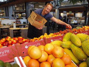 Keith Goodale from Vegetable Butcher fills up the bins during the exclusive opening of the Calgary Farmers' Market's second location, CFM West, located at 25 Greenbriar Drive N.W. in Calgary on Thursday, August 11, 2022.