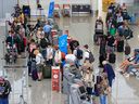 Travelers line up to check in at Calgary International Airport on Tuesday, August 23, 2022.  The federal government has announced nearly $2 million in new funding to help the airport recover from the effects of the pandemic.