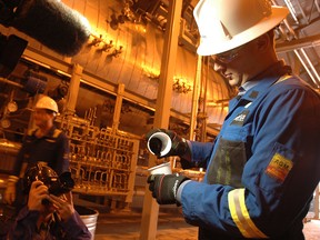 Drew Zieglgansberger, executive vice president of natural gas and technical services for Cenovus Energy, demonstrates the molasses-like consistency of bitumen during a press tour at the Christina Lake facility in 2011.