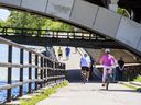 Cyclists ride along the Bow River path in Calgary.
