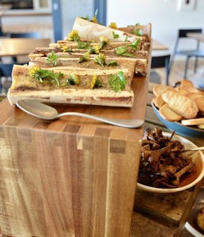 At Jasper's newest restaurant, Terra, chef Tyler Tays offers farm-to-table dishes to share, like this small plate of bone marrow with chanterelles, confit onions and parsley salad with sourdough. tart, decorated with dandelions.  Photo, Theresa Storm