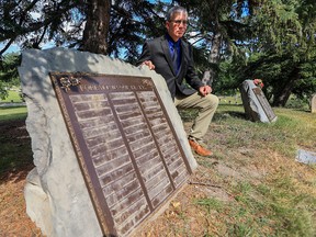 Calgary police Staff Sgt. Colin Chisholm displays an empty memorial stone in Queen's Park Cemetery on Aug. 26. Hundreds of bronze memorial plaques have been stolen from the cemetery.