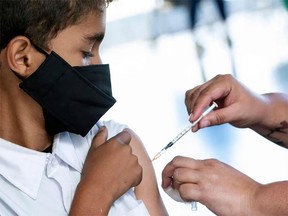 FOTO DE FIȘAR: Un copil care primește un vaccin.