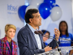 Infosys President Ravi Kumar speaks during a company announcement in Calgary on Sept. 26 as Mayor Jyoti Gondek, left, looks on.