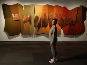 Curator Michele Hardy in front of F. Douglas Motter’s This Bright Land, part of the new exhibit at the Nickle Galleries called Prairie Interlace: Weaving, Modernisms and the Expanded Frame 1960-2000. Gavin Young/Postmedia