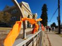 Stanley Jones Elementary School students walk past orange ribbons they have tied to a fence outside their school on Wednesday, September 29, 2021 in honour of the first National Day for Truth and Reconciliation. September 30 honours the lost children and survivors of residential schools, their families and communities. 