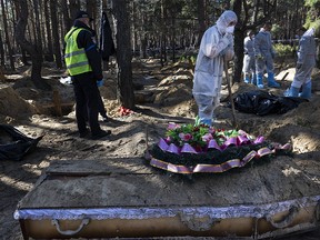 FILE PHOTO: Rescue workers and forensic police exhume bodies from unidentified makeshift graves at the Pishanske cemetery on September 21, 2022 in Izium, Ukraine. The bodies will be examined by forensic officials for possible war crimes. Izium was recently liberated from Russian occupation after six months. Approximately 440 bodies are buried at the cemetery, so far over 338 bodies have been exhumed, taken to the morgue in Kharkiv.