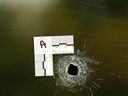 A bullet hole is visible in the front window of the Monte Carlo Bar and Lounge in Calgary on Sunday, September 18, 2022.