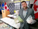 RCMP Staff Sgt.  Jeff Ringelberg shows off some of the $4.5 million worth of drugs and nearly $1 million in cash that was seized as part of 'Project Carlos', an ongoing criminal network investigation that saw numerous suspects arrested in homes across Calgary on Tuesday, September 13, 2022 . 