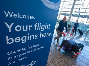 Passengers move through the Calgary International Airport on Monday.