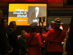 The Grey Cup is carried in at the start of the tribute at the Jack Singer Concert Hall.
