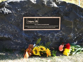 A City of Calgary plaque, flowers and rock is displayed during a dedication ceremony in Calgary on Sunday, October 9, 2022 for Paul “Smokey” Wilkinson. A green space near 14 St. and Memorial Dr. NW was dedicated in Wilkinson’s name.