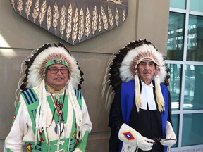 FILE PHOTO: Traditional knowledge keeper Leonard Bastien, who blessed the ceremonial opening of the Calgary Indigenous Court, (left) and provincial court Judge Eugene Creighton pose in their transitional headdresses worn for the opening of the new courtroom in Calgary.