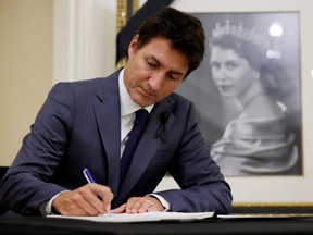 Prime Minister Justin Trudeau signs a book of condolences for Britain's Queen Elizabeth at Rideau Hall in Ottawa, Friday, Sept. 9, 2022.