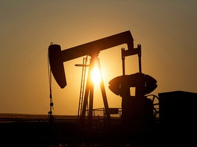 An oil pump jacks up at sunset on a farm near Calgary.