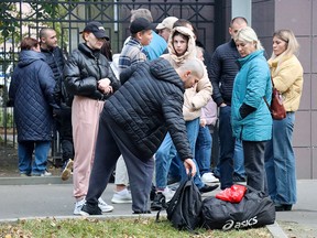 Men drafted into the Russian army during partial mobilization say goodbye to relatives and friends outside a military commissariat in Moscow on Friday, Sept. 23, 2022.